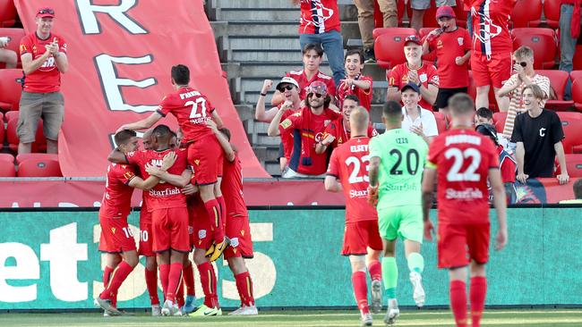 James Troisi celebrates his late winner with Adelaide United teammates in front of the sparse Hindmarsh Stadium crowd. Picture: AAP Image/James Elsby