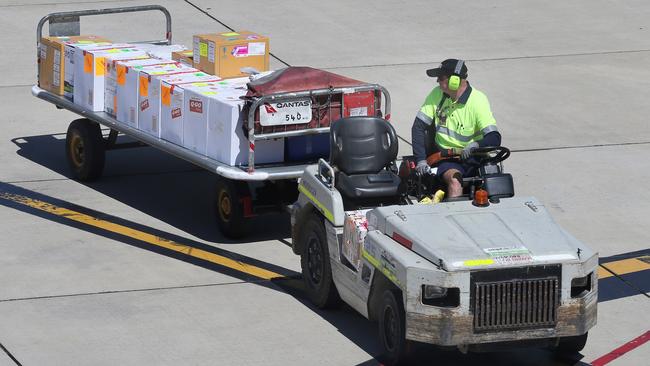 The first batch of coronavirus vaccine to arrive in SA is taken off a Qantas flight at Adelaide Airport. Picture: Dean Martin