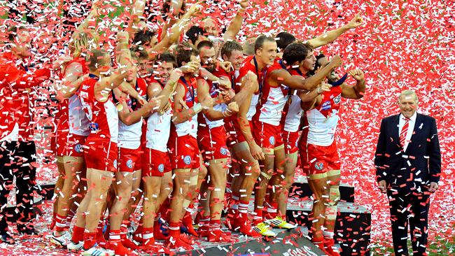 Bob Skilton (right) in a sea of red and white confetti after the 2012 Grand Final victory over Hawthorn.