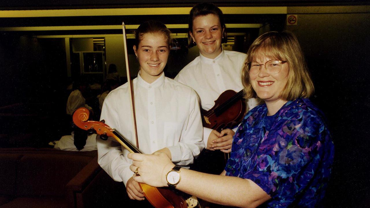 Bundaberg State High School string orchestra students Carly Christensen and Katrina Boyd with conductor Christine Buwalda at the Fanfare 98 Grand Final concert in 1998.