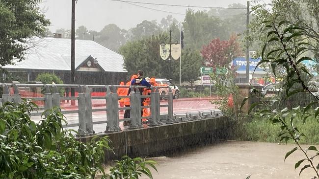 Local SES units are working to flatten the sides of the Picton bridge to allow the water to flow over the bridge without flooding the main street. Picture: Adelaide Lang