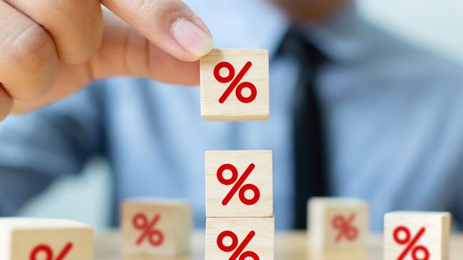 Interest rate financial and mortgage rates concept. Hand putting wood cube block increasing on top with icon percentage symbol upward direction