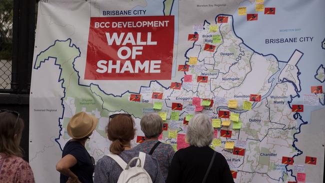 Rally participants look at the "wall of shame'' - controversial projects in recent years across Brisbane.