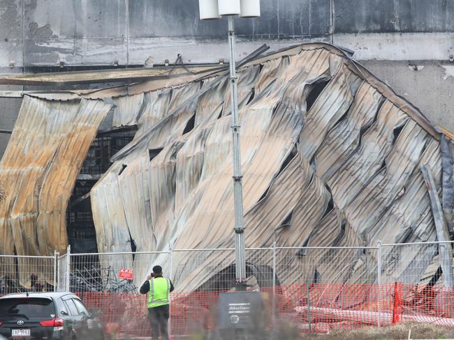 Security keep watch at the site of a large factory fire in Derrimut on Saturday. Picture: David Crosling