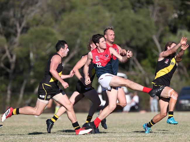 Round 2 of the QAFL Australian rules competition between Labrador and Surfers Paradise. Daniel Charlseworth of Surfers Paradise gets a kick away. Photograph : Jason O'Brien