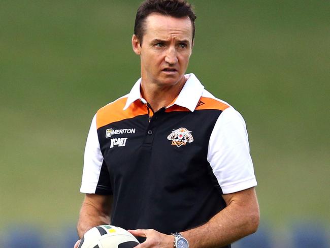 Tigers coach Jason Taylor watches his team warm up for their trial match against the Sharks in 2015.