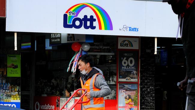 MELBOURNE, AUSTRALIA - NewsWire Photos JUNE 30, 2022: People walk past a billboard promoting tonight $60m Powerball, in Melbourne.Picture: NCA NewsWire / Luis Enrique Ascui