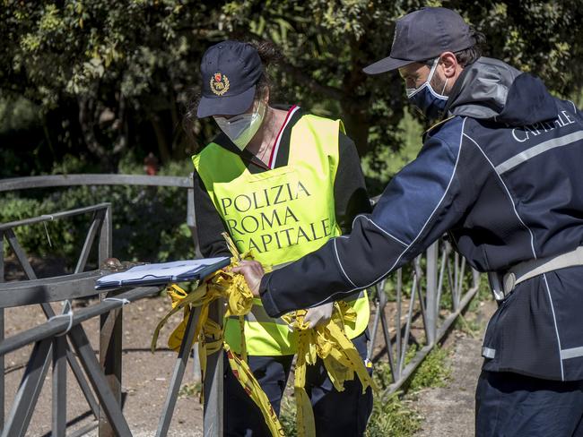 Italian police remove the seals from the entrance of Rome's Caffarella park as it reopened after several weeks of closure. Picture: AP