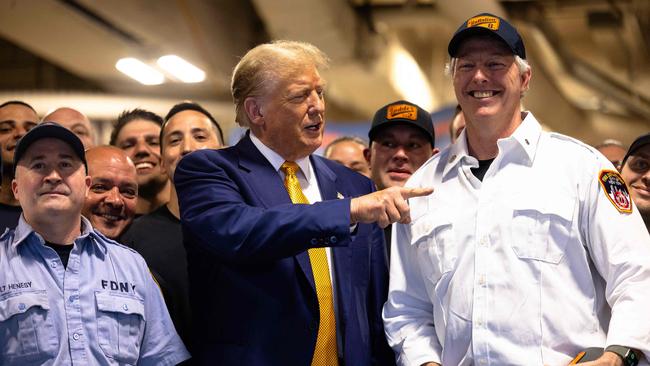 Donald Trump poses for photos with New York firemen, to whom he delivered pizza on Thursday after attending court. Picture: Getty Images via AFP