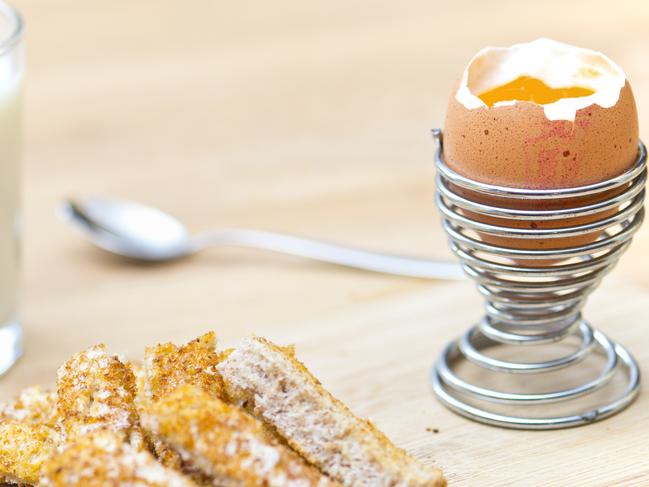 Boiled egg and soldiers with glass of milk