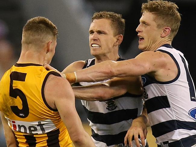 Sam Mitchell goes toe-to-toe with Cats Joel and Scott Selwood. Picture: Wayne Ludbey