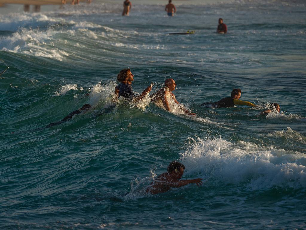 Surfers making there way out to sea to pay tribute to Annalise Braakensiek at the Memorial held at Bondi Beach around 7am Wednesday January 16 Image Picture: Monique Harmer