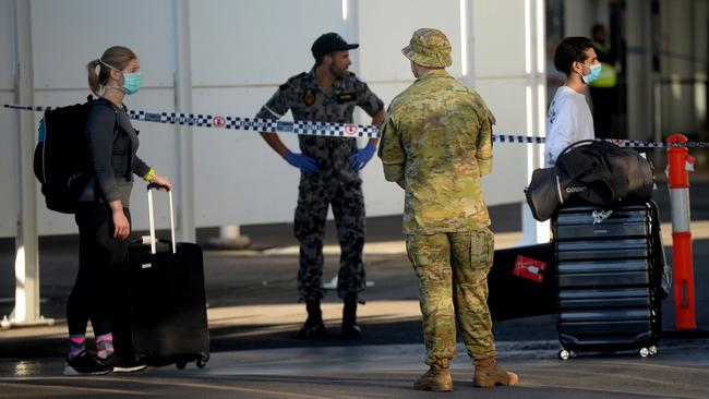 New arrivals at Sydney International Airport are ushered into waiting buses for hotel quarantine. Picture: Jeremy Piper