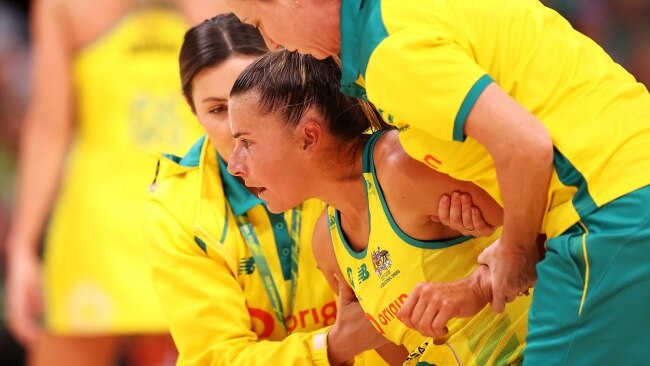 Maddy Proud of Australia is helped to her feet after copping a nasty blow. (Photo by Mark Kolbe/Getty Images for Netball Australia)