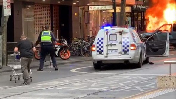 A man with a trolley comes to the aid of police during the Bourke St incident.