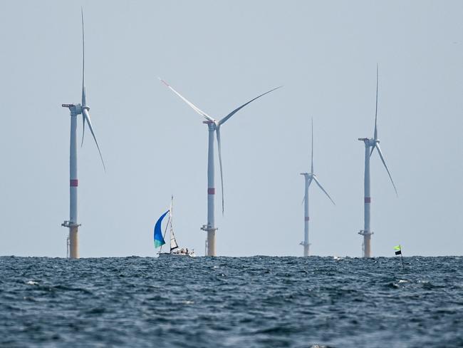 (FILES) People sail next to Saint-Nazaire offshore EDF wind park off Le Croisic, western France, on June 26, 2023. Driven by a renewed interest in the atom, EDF intends to implement third-generation reactors (EPR) in France and Europe (Photo by Sebastien SALOM-GOMIS / AFP)