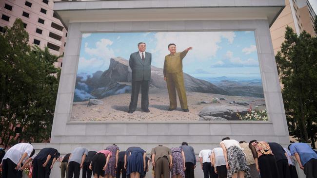 North Koreans bow before a mosaic of portraits of late North Korean leaders Kim Il-sung and Kim Jong-il, in Pyongyang. Picture: AFP.