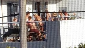 Backpacker guests gather on a terrace at the rear of the Sydney Collaroy Beach House hostel. Picture: Facebook