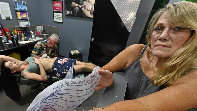 Murder victim Shandee Blackburn’s sister, Shannah Blackburn, gets a tattoo stating ‘Not guilty does not mean innocence’, watched by her mother Vicki Blackburn in Mackay. Picture: Lyndon Mechielsen