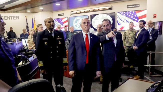 US Vice President Mike Pence, (centre), Surgeon General Jerome Adams, (left), and Health and Human Services Secretary Alex Azar (right) look at a large monitor displaying a tally of total coronavirus cases, deaths, and recovered, as they tour the Secretary's Operations Center following a coronavirus task force meeting at the US Department of Health and Human Services. Picture: AP