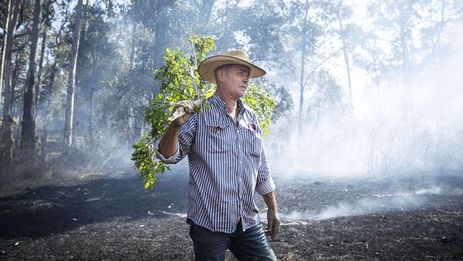 Cattle farmer David Callaugham helps to fight a fire on his property at Possum Brush south of Taree. Picture: John Feder