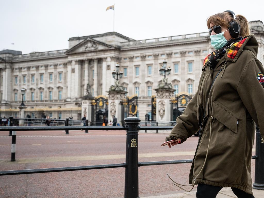 A woman wearing a face mask walks past Buckingham Palace. Picture: Leon Neal/Getty Images