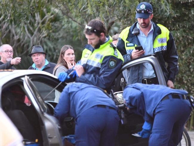 Onlookers watch as John Dunne is treated for wounds caused by a speargun spear in his chest. Picture: Sebastien Dekker