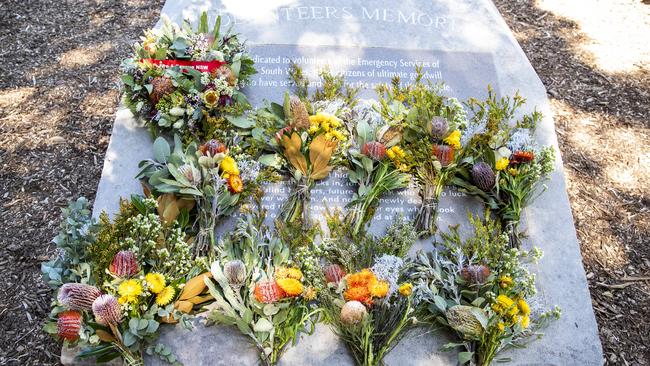 Flowers lay across the Volunteers Memorial. Picture: NCA NewsWire / Jenny Evans