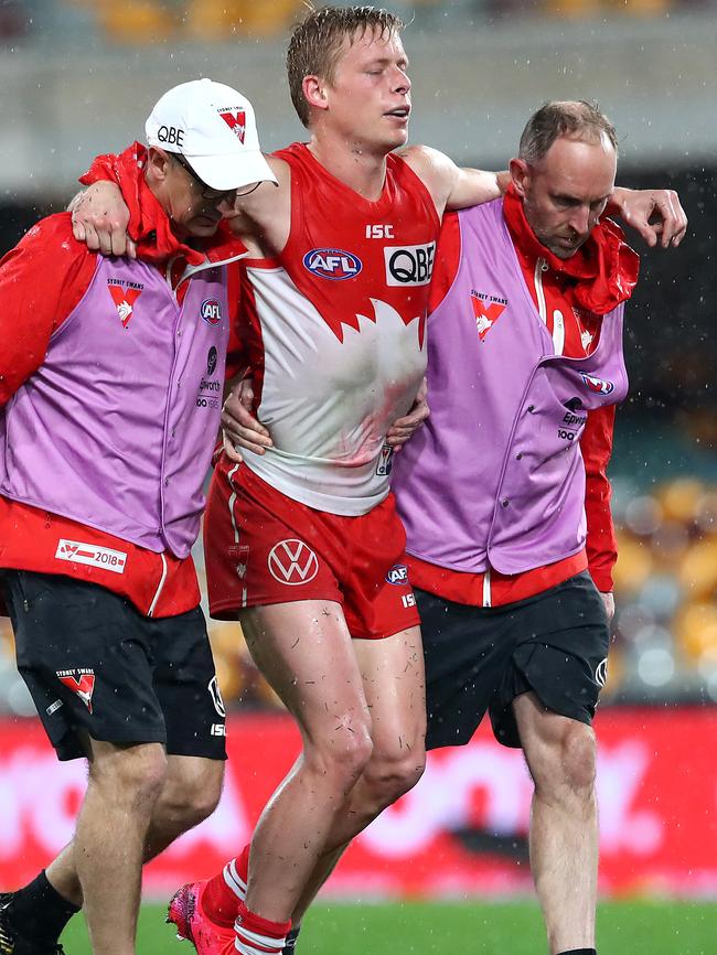 Isaac Heeney is carried from the field by trainers after hurting his ankle. Picture: Jono Searle/AFL Photos/via Getty Images