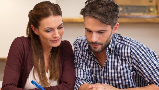 A happy young couple discussing with each other their financial affairs.