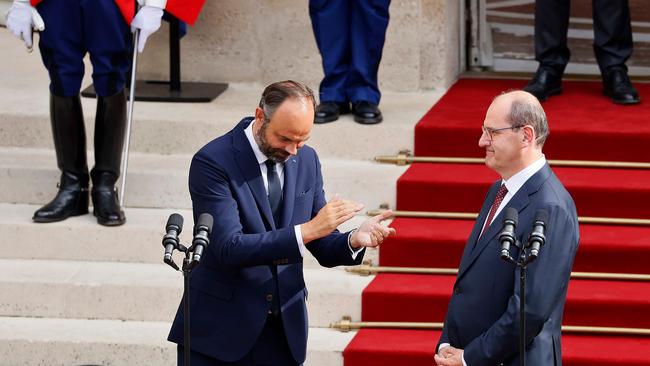 Former French Prime Minister Edouard Philippe, left, applauds newly-appointed Prime Minister Jean Castex in the courtyard of the Matignon Hotel during the handover ceremony in Paris.