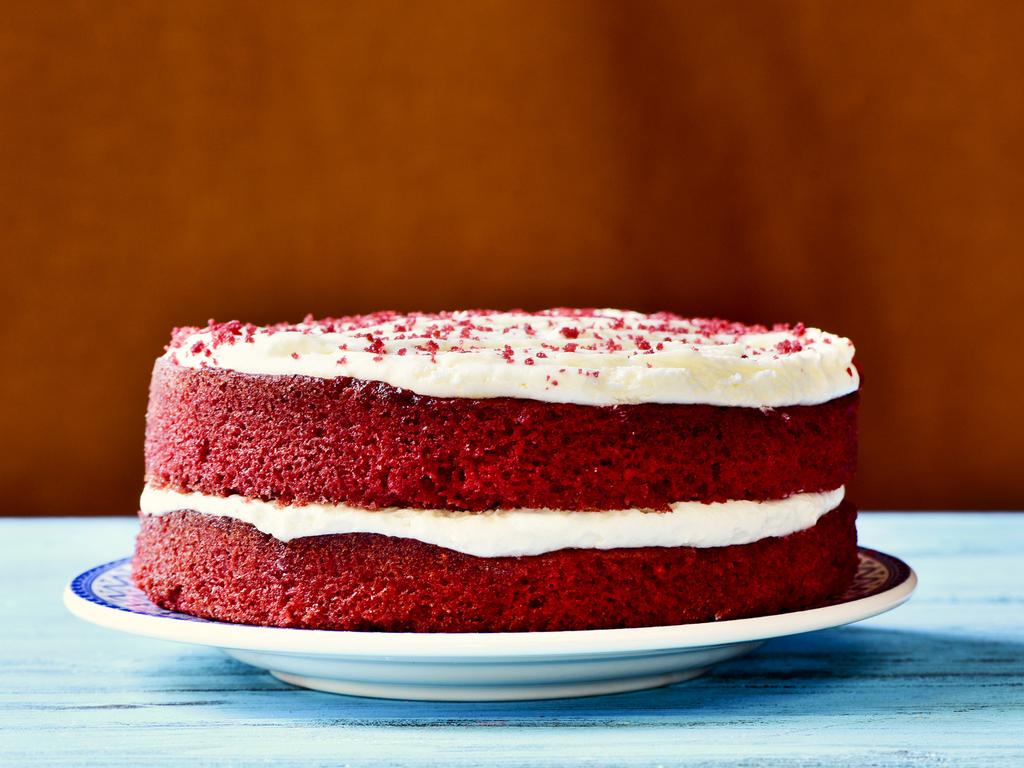 an appetising red velvet cake on a rustic blue wooden table