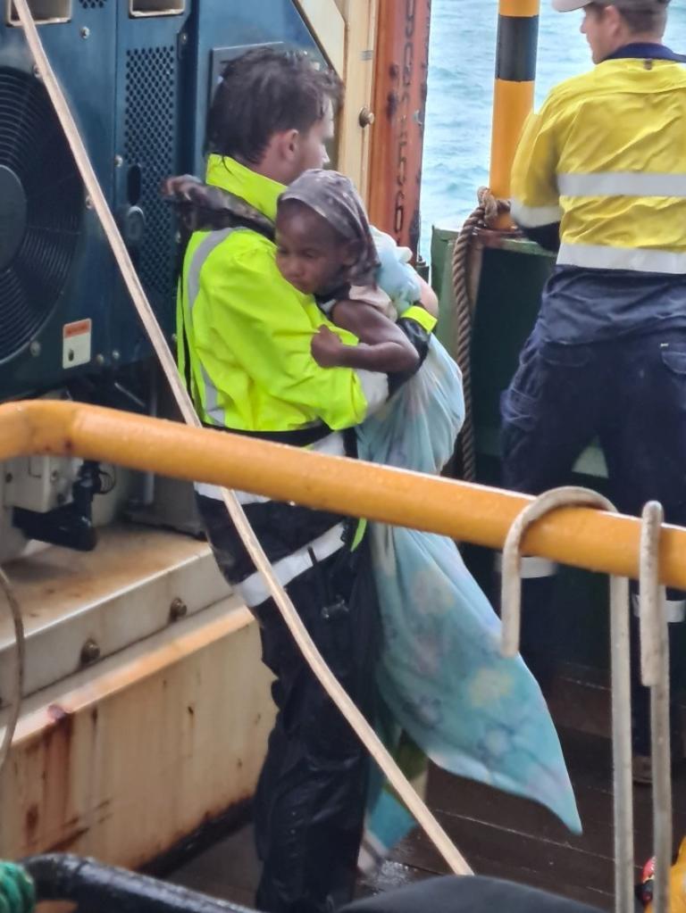 A one-year-old baby is comforted after the ordeal by A Sea Swift worker. Picture: Sea Swift