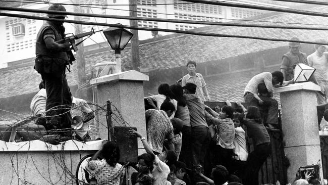 Vietnamese scale the wall of the US Embassy ahead of the fall of Saigon in April 1975.