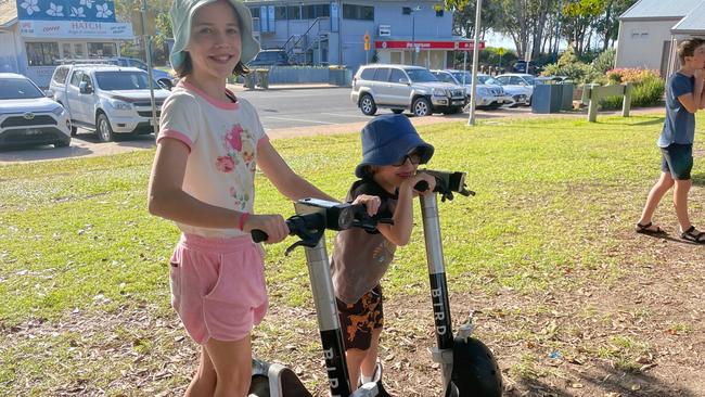 Isabelle and Miles Jacks on some of the Bird e-scooters near the pier in Hervey Bay.