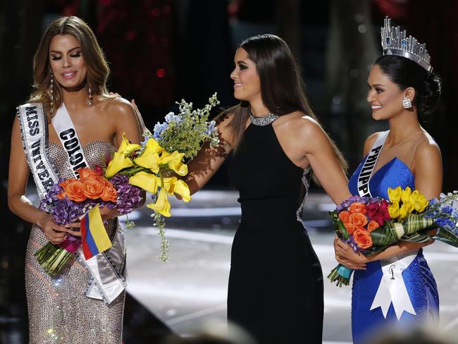 Holding it together ... the flowers and sash were taken from Miss Colombia Ariadna Gutierrez, left, and given to Miss Philippines Pia Alonzo Wurtzbach, right. Picture: AP