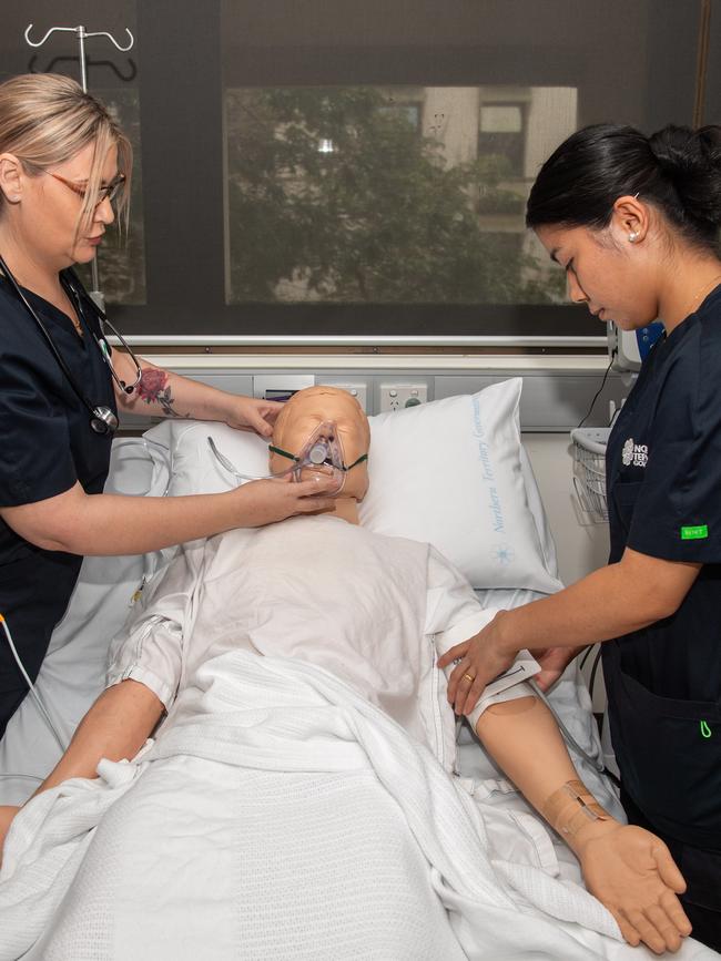 Grad nurses working on one of the hospital dummies. Picture: Pema Tamang Pakhrin