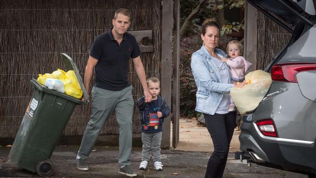 Mark and Davina Geels with their children Hamish, 3 and Imogen, 1, as they load excess rubbish into their car. Picture: Jake Nowakowski