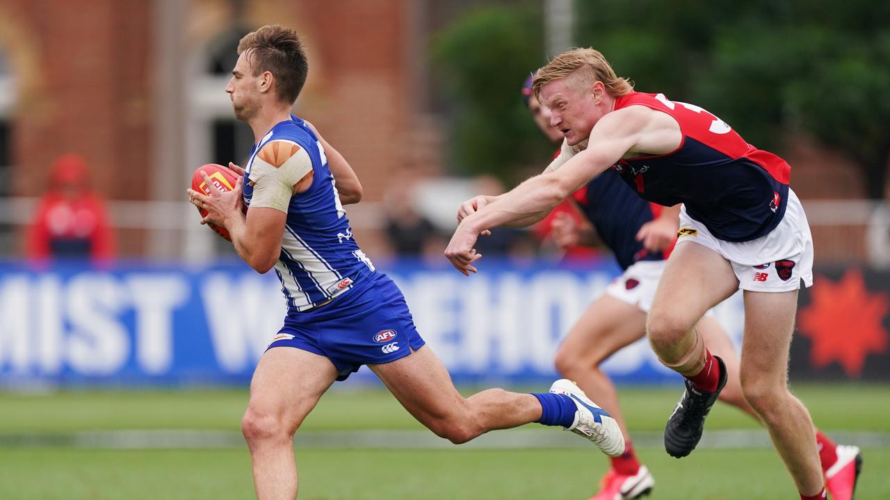 Dom Tyson runs with the ball from Harrison Petty during a pre-season hit out match between North Melbourne and Melbourne at Arden Street Oval on Friday. Picture: AAP Image/Michael Dodge