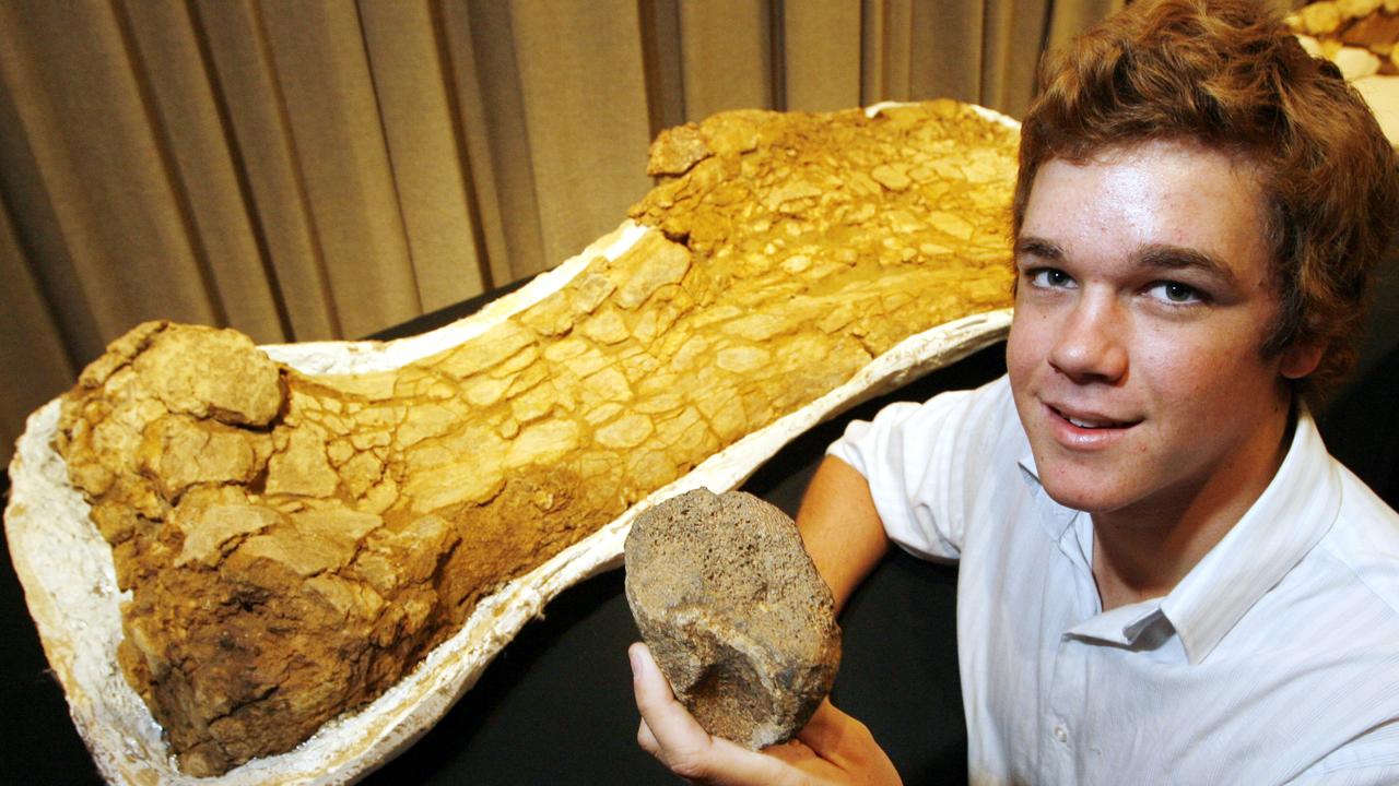 Qld teenager Sandy Mackenzie holding originally found fossil bone of Titanosaur dinosaur, next to larger fossil bone discovered by archaeologist after dig on his parents sheep and cattle property near Eromanga Qld 03 May 2007. /Fossils