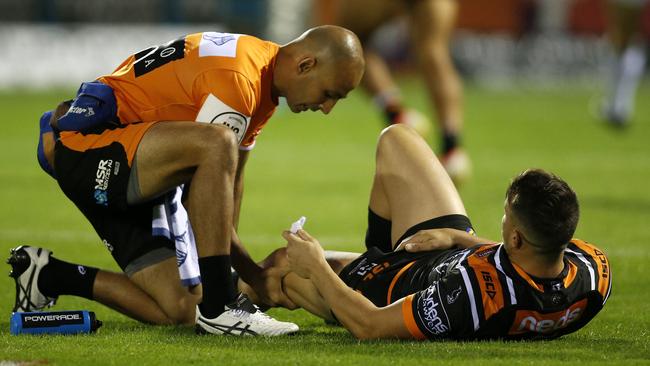 Josh Reynolds has his injured knee assessed by a trainer. Picture: AAP