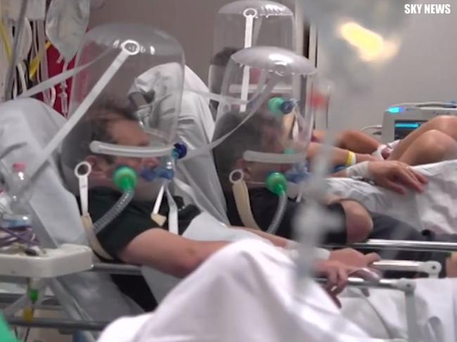 Italian patients being treated for coronavirus are seen with their heads zipped into oxygen helmets at a hospital in Milan. Picture: Sky News