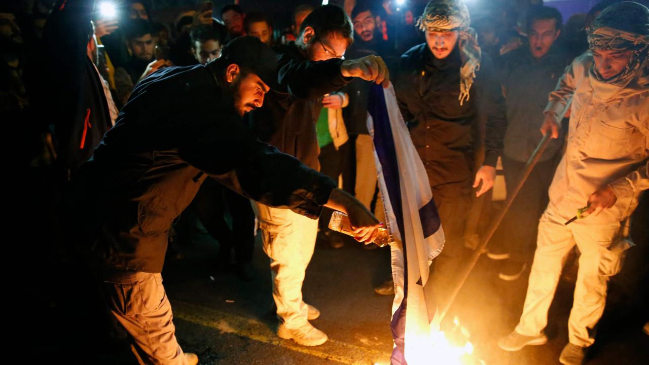 Iranian students and demonstrators burn Israeli flags. Picture: AFP