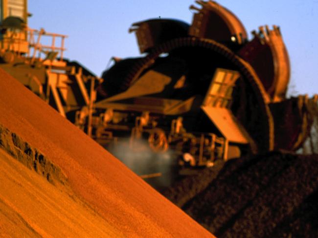 An undated handout photo made available 03 August 2005 shows a worker inspecting iron ore stockpiles at the outback location of Marandoo. Rio Tinto reports a record first-half net profit of 2.17 billion US dollars 03 August 2005. Rio Tinto posted the result, well ahead of market forecasts following a China-driven boom for resources and solid production figures. AFP PHOTO/RIO TINTO/HO (EDITORIAL USE ONLY)