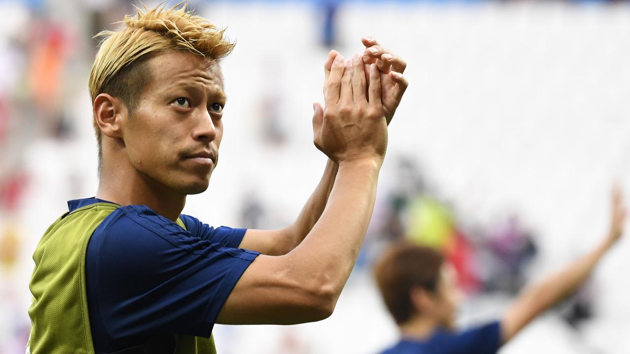 Keisuke Honda celebrates Japan’s qualification for the second round at the World Cup.