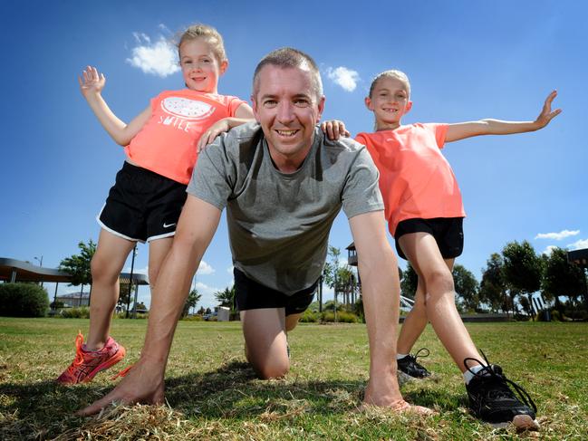 Woodlea resident Ryan White and daughters Chloe, 5, and Emma, 7, are warming up for the Run for the Kids. Picture: Andrew Henshaw