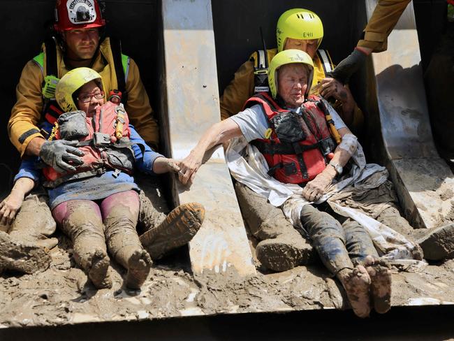 It was a wild ride for these residents rescued with a bulldozer. Picture: AFP