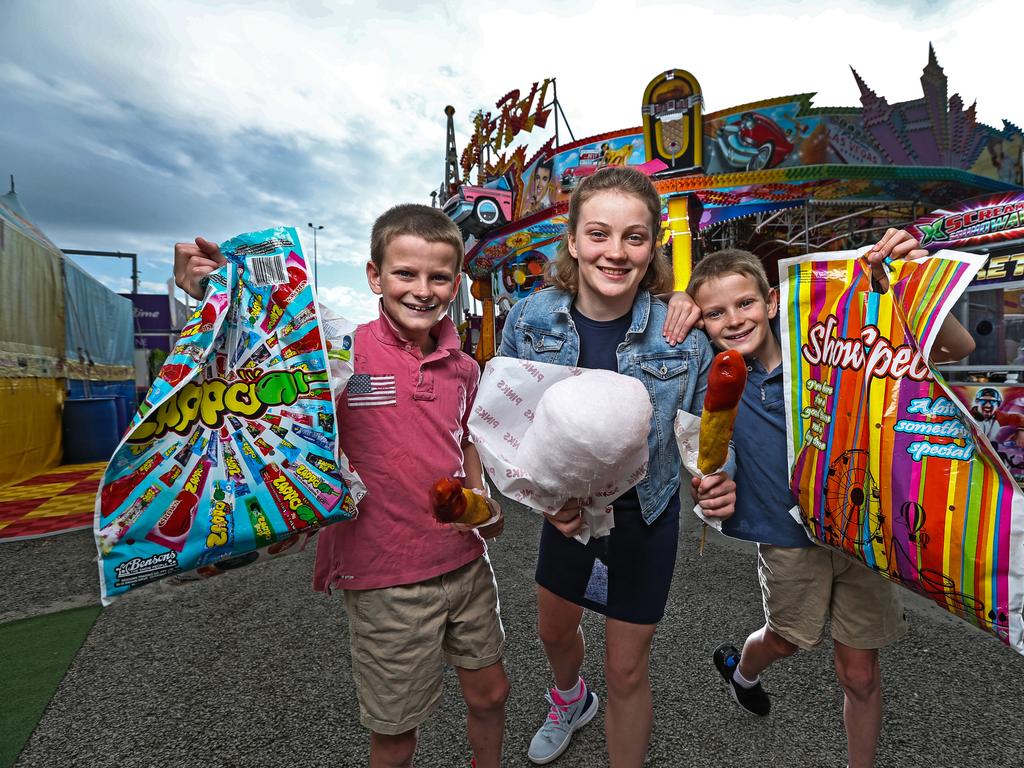 Clem Cook, 11 alongside twin brothers Rupert and Banjo, nine, ahead of the first day of the 2022 Ekka. Picture: Zak Simmonds