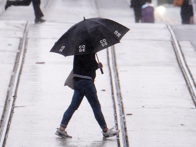 MELBOURNE, AUSTRALIA - NewsWire Photos DECEMBER 19, 2021: People are seen running from the rain in melbourneÃs CBDPicture: NCA NewsWire / Luis Enrique Ascui