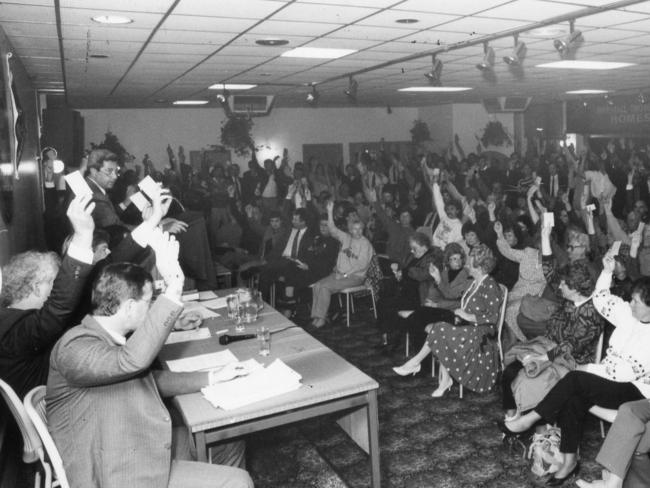 West Torrens Football Club members raise hands to vote during a meeting to decide the SANFL merger of Woodville Football Club with West Torrens.